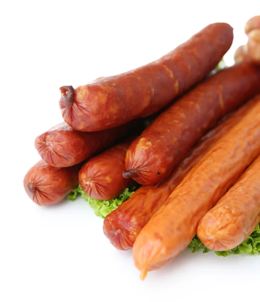 Surtido de salchichas finas con hojas de ensalada de lechuga, aisladas en blanco —  Fotos de Stock