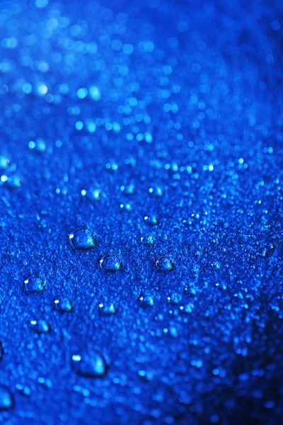 Капли воды на фоне цветной поверхности, вид на макрос — стоковое фото