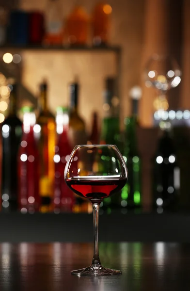 Bicchiere di vino con bar sullo sfondo — Foto Stock