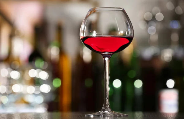 Glass of wine with bar on background — Stock Photo, Image