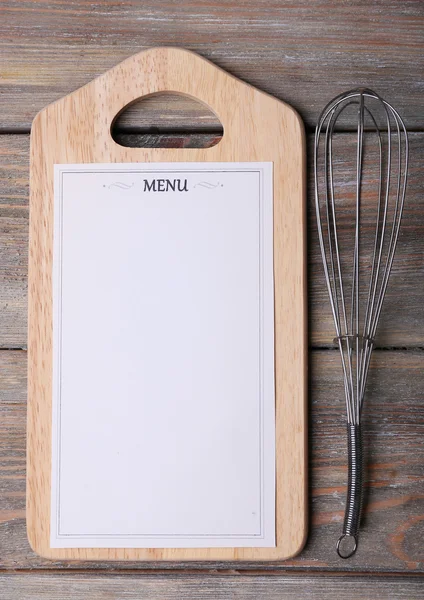 Tagliere con foglio di carta Menu con frusta uovo su fondo rustico in legno — Foto Stock