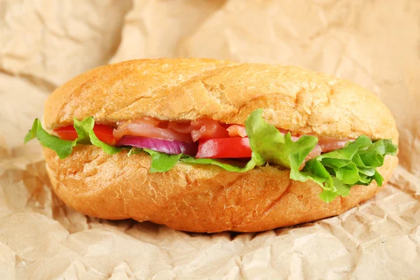 Sandwich med lax på papper bakgrund — Stockfoto