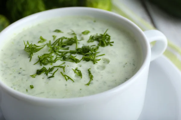 Gurkensuppe in Schüssel auf farbigem Holztischhintergrund — Stockfoto