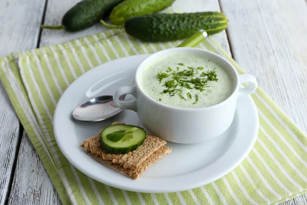 Cucumber soup in bowl on color wooden table background — Stock Photo, Image