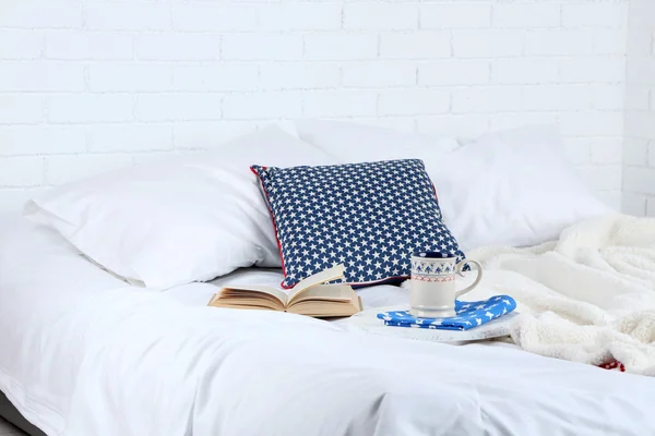 Book and cup of tea on bed close-up — Stock Photo, Image