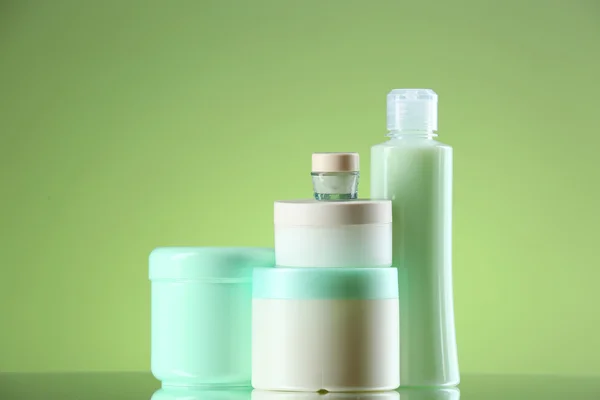 Cosmetic bottles on light green background — Stock Photo, Image