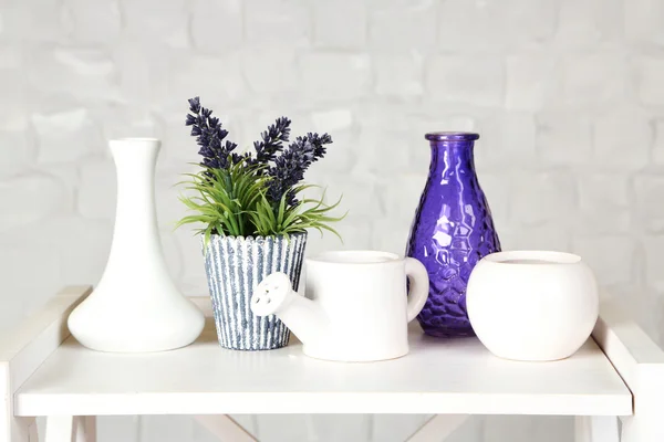 Intérieur avec vases décoratifs et plante sur le dessus de la table et fond mural en brique blanche — Photo