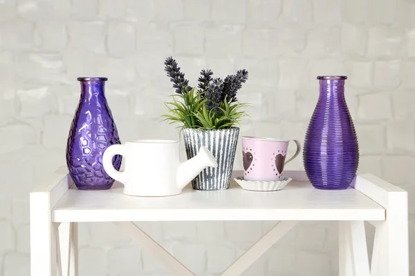 Interior with decorative vases and plant on table top and white brick wall background — Stock Photo, Image