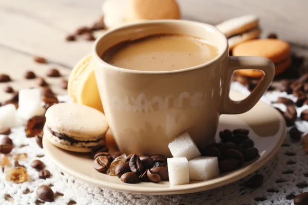 Macaroni colorati delicati e caffè in tazza su sfondo tavolo in legno — Foto Stock