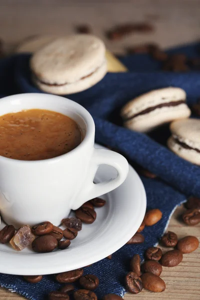 Macarrones coloridos suaves y café en taza sobre fondo de mesa de madera —  Fotos de Stock