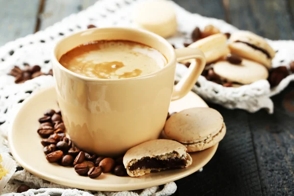 Mjuka färgglada macaroons och kaffe i mugg på träbord bakgrund — Stockfoto