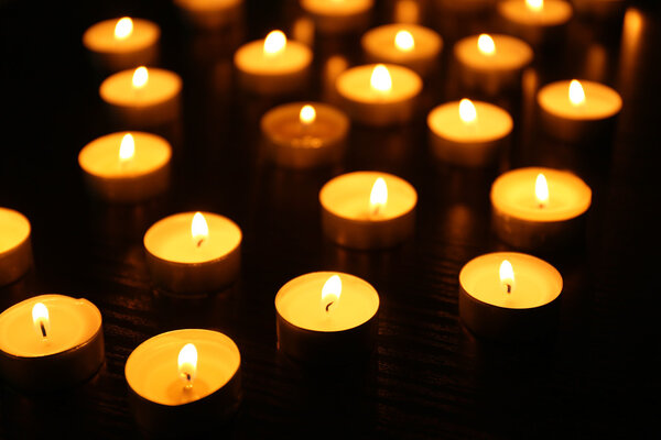 Зажигание свечей на тёмном фоне