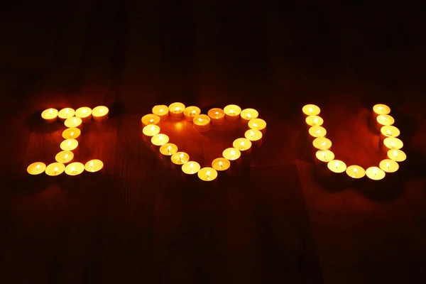 Words I LOVE YOU formed by burning candles on dark background — Stock Photo, Image