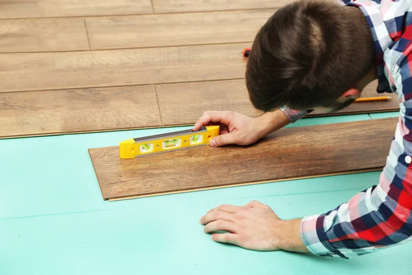 室内安装层压板地板的木匠工人 — 图库照片