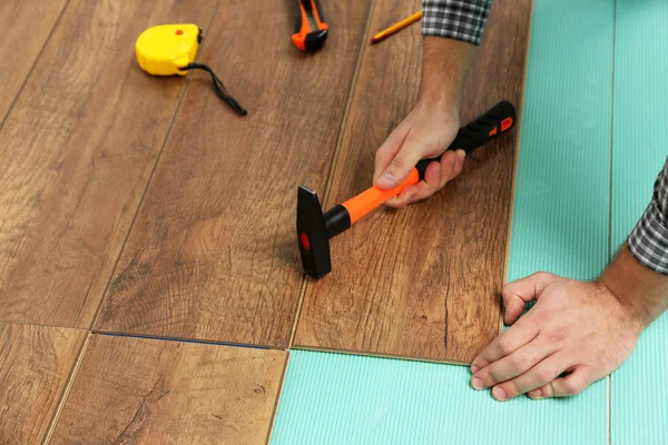 Trabajador carpintero instalación de pisos laminados en la habitación — Foto de Stock