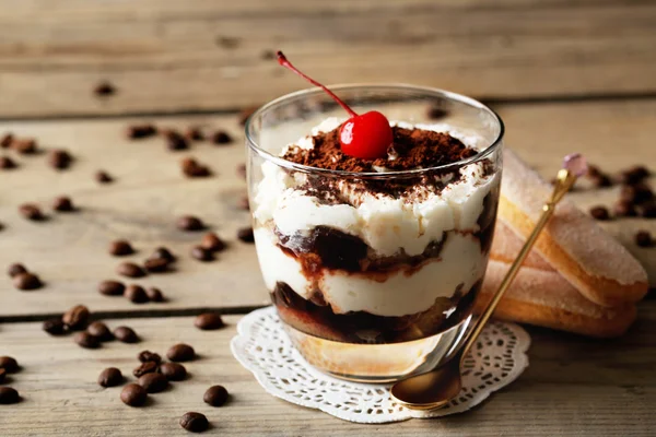Смачний десерт тірамісу в склі, на дерев'яному фоні — стокове фото
