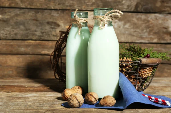 Ahşap arka plan üzerinde doğal dekor ile taze süt şişe — Stok fotoğraf