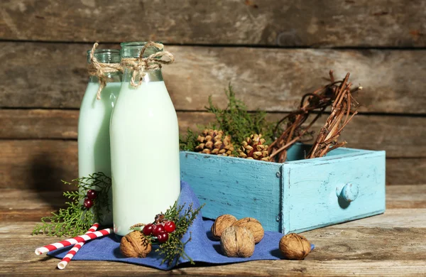 Flaskor av färsk mjölk med naturlig inredning, på trä bakgrund — Stockfoto