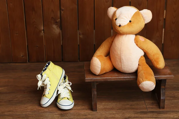Медвежья игрушка на скамейке на деревянном фоне — стоковое фото