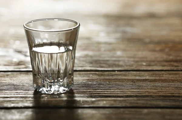 Verre d'eau minérale propre sur fond de planches de bois rustiques — Photo