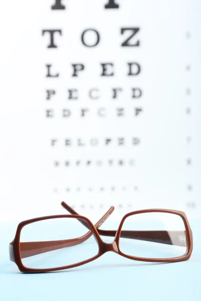 Eye glasses on eyesight test chart background — Stock Photo, Image