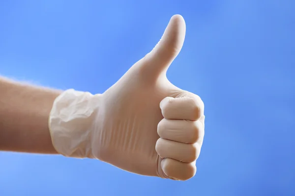 Doctor hand in sterile gloves on blue background — Stock Photo, Image