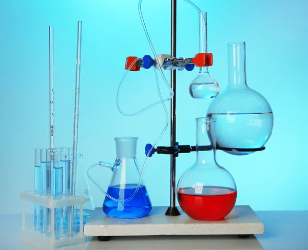 Fixed laboratory glassware on support on colorful background — Stock Photo, Image