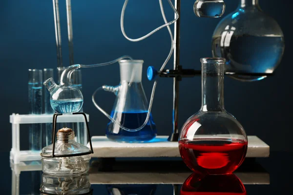 Fixed laboratory glassware on support on dark colorful background — Stock Photo, Image