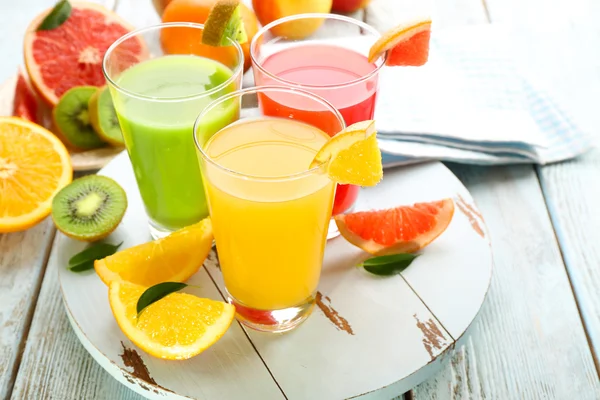 Fresh juices with fruits on wooden table — Stock Photo, Image