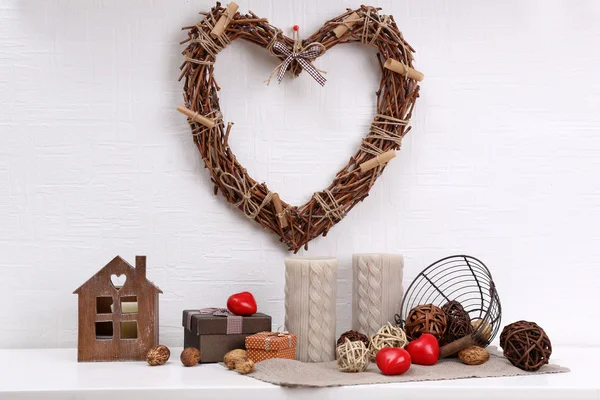 Romantic still life with wicker heart and design details on shelf and white wall background — Stock Photo, Image