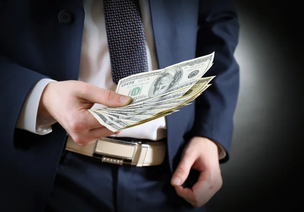 Επιχειρηματίας δίνει χρήματα σε σκούρο φόντο — Φωτογραφία Αρχείου