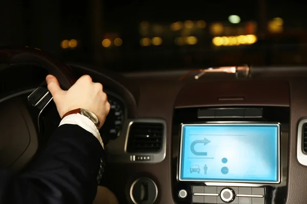 El hombre que conduce su coche moderno en la noche en la ciudad, primer plano — Foto de Stock