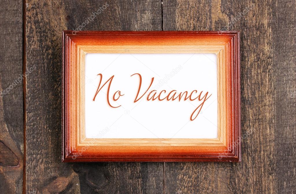 No Vacancy text in frame on wooden background