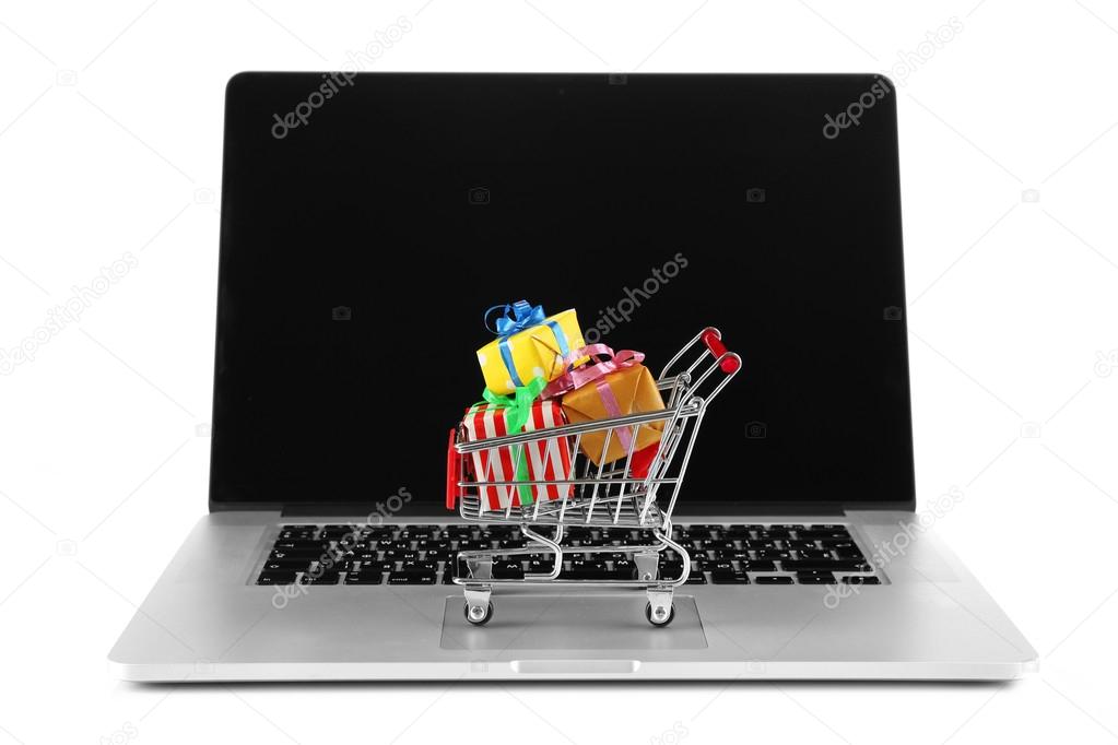 Laptop with small shopping cart full of gifts isolated on white background