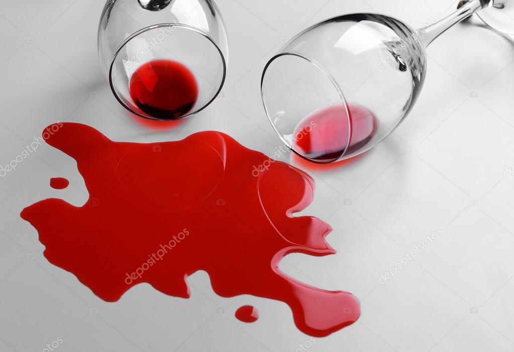 Red wine spilled from glass on white background