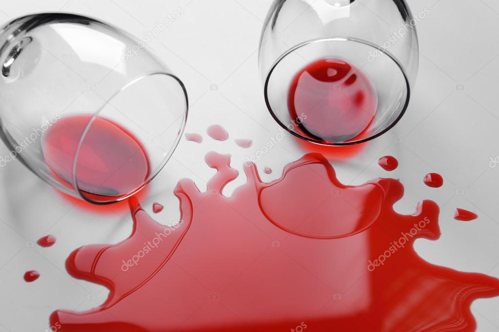 Red wine spilled from glass on white background