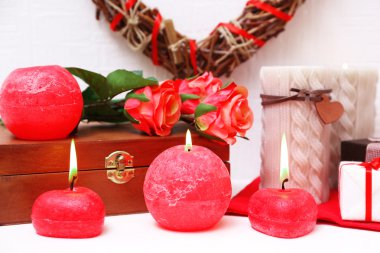 Hasır kalp ve mum ile romantik natürmort şöminenin ve beyaz duvar arka plan üzerinde ışıklar