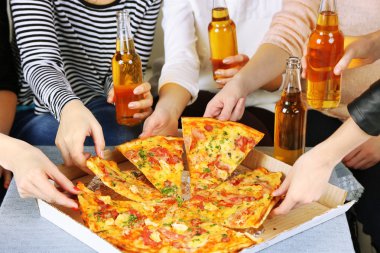 Arkadaşlar el ile şişe bira ve pizza, yakın çekim