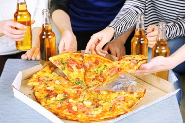 Arkadaşlar el ile şişe bira ve pizza, yakın çekim