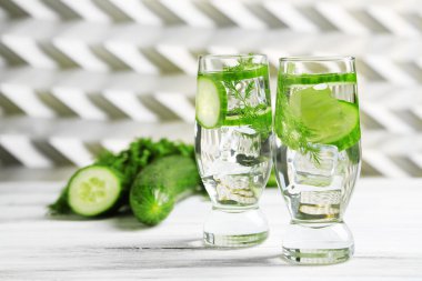 Gözlük ile taze organik salatalık suyu üzerinde açık renkli ahşap tablo