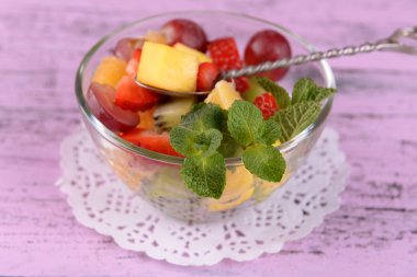 Cam renk ahşap zemin üzerine nane ile meyve salatası