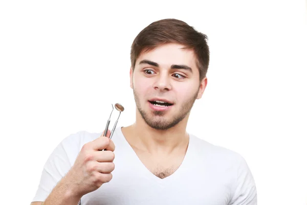 Hombre con herramientas dentales aisladas en blanco — Foto de Stock