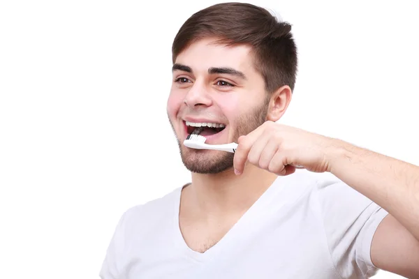 Retrato de un joven sonriente con cepillo de dientes aislado en blanco — Foto de Stock