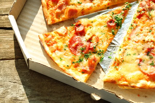 Tasty pizza on wooden table — Stock Photo, Image