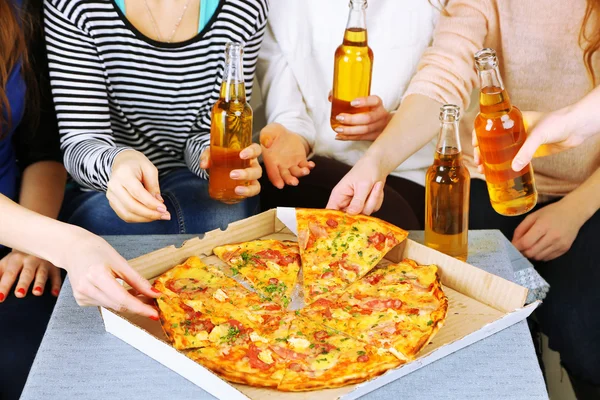 Friends hands with bottles of beer and pizza, close up — Stock Photo, Image