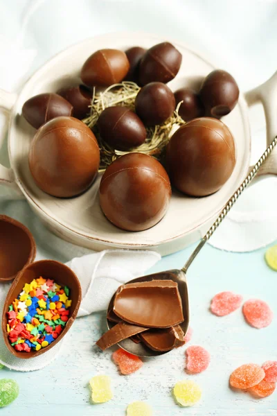 Čokoládová velikonoční vejce na talíři, na barevné dřevěné pozadí — Stock fotografie