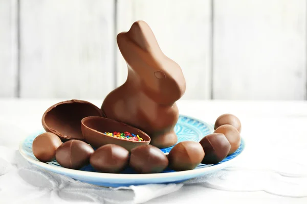 Čokoládová velikonoční vejce a králík na desce, na barevné dřevěné pozadí — Stock fotografie