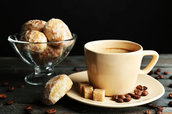 Secangkir kopi dan kue lezat di atas meja kayu, dengan latar belakang gelap — Stok Foto