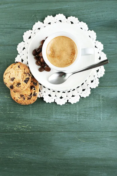 Tasse Kaffee und leckeres Gebäck auf farbigem Holzhintergrund — Stockfoto