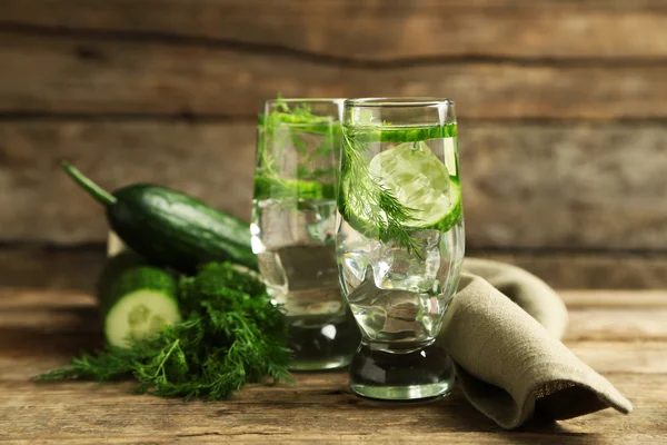 Glasses with fresh organic cucumber water on wooden table — Stock Photo, Image